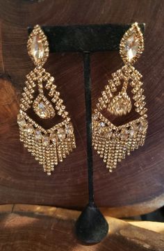 "These fun and stylish rhinestone extra long earrings are a great statement piece! Oversized rhinestone earrings with gold crystals. Pageant, prom, or bridal! Size of earrings: 2.25\" Wide and 4.5\" Long. Color: Gold Rhinestones Base Metal: Gold Clip on available! Just select \"clip on\" under style More colors available! Just send us a message! Looking for a matching bracelet? https://www.etsy.com/listing/592776278/gold-prom-bracelet-gold-rhinestone?ref=related-3 https://www.etsy.com/listing/60 Prom Bracelet, Large Gold Earrings, Gold Rhinestone Earrings, Extra Long Earrings, Pageant Earrings, Clear Crystal Earrings, Gold Prom, Gold Crystals, Gold Chandelier Earrings