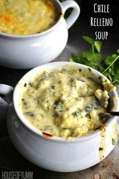 two white bowls filled with soup and garnished with parsley on the side