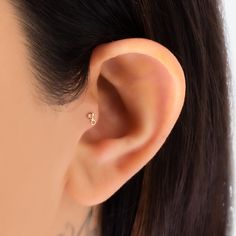 a woman's ear is shown with a small diamond in the middle of it