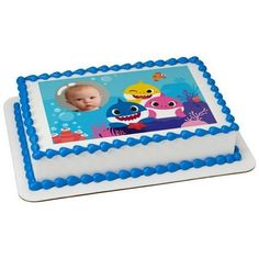 a blue and white cake with an image of a baby shark on it's side