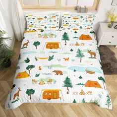 a bed with camping themed sheets and pillows