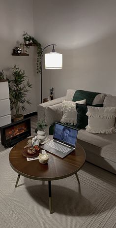 a living room filled with furniture and a laptop computer on top of a coffee table