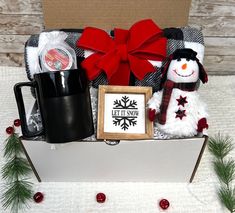 a christmas gift box with a snowman, coffee mug and other holiday items in it