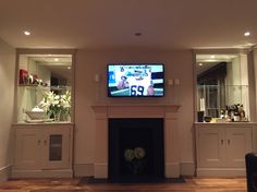 a flat screen tv mounted above a fireplace in a living room