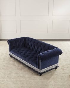 a blue couch sitting on top of a carpeted floor