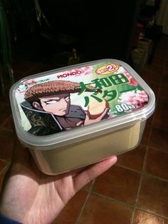 a person holding up a container of yogurt with an anime character on it