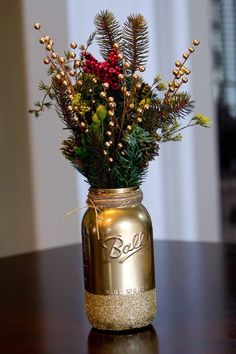 a mason jar filled with pine cones and berries