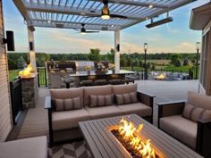 an outdoor living area with couches and fire pit