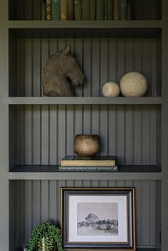 a bookshelf filled with lots of books next to a vase and other items