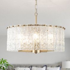 a chandelier hanging over a bed in a room with white walls and pillows