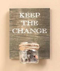 a sign that says keep the change hanging on a wall with coins in a jar