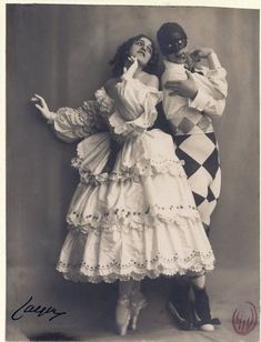 an old photo of two people dressed in costume and posing for the camera with their arms around each other