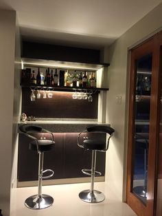 two bar stools sit in front of a counter