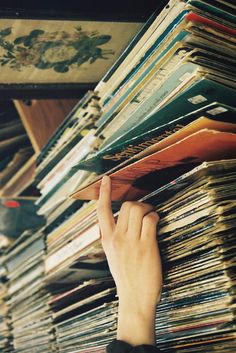 a person reaching for records on a shelf