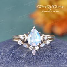 an engagement ring with a pear shaped blue topazte surrounded by small white diamonds