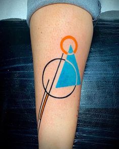 a tattoo on the leg of a person with an orange and blue triangle in it