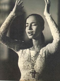 an old photo of a woman with her hands in the air