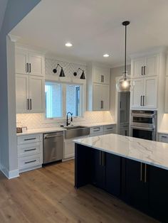 an empty kitchen with white cabinets and marble counter tops