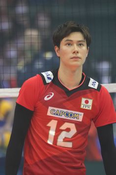 a young man standing in front of a volleyball net