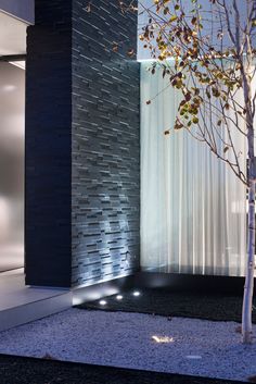 LA modern loft home entryway with textured black tile wall, outdoor lights & landscaping. Black Tile Wall, Tiles Wall Design, Textured Tile, Wall Outdoor, Black Tile, Patio Fireplace