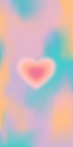 a blurry background with a pink heart in the center and blue, green, yellow, and pink colors