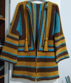 a crocheted jacket hanging on a hook