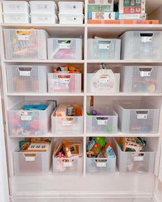 the closet is filled with lots of plastic containers and bins for storing children's toys