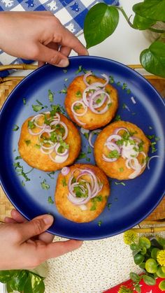 a blue plate topped with food on top of a wooden table next to green plants