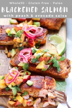 grilled salmon with peach and avocado salsa on a cutting board next to a fork