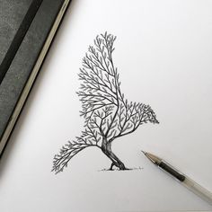 a pencil drawing of a tree on top of a piece of paper next to a pen