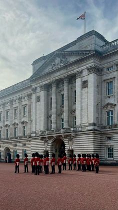 a group of men standing in front of a large building