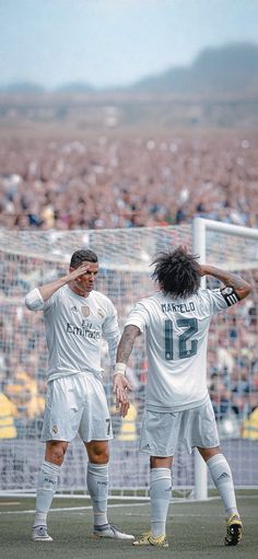 two soccer players are congratulating each other in front of an audience at a sporting event