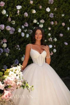 a woman in a wedding dress standing next to flowers