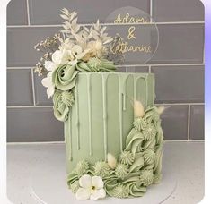 a green cake with white flowers on top