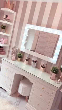 a vanity with a mirror and lights on it in a room that has striped walls