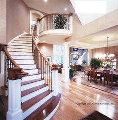 a large open floor plan with wood floors and white railings on the second story