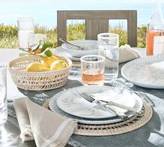 an outdoor table set with plates and silverware