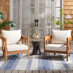 two wooden chairs sitting next to each other on top of a rug