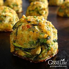 zucchini balls with spinach and cheese are on a black surface, ready to be eaten