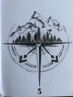 a drawing of a compass with trees and mountains in the background, on top of a piece of paper