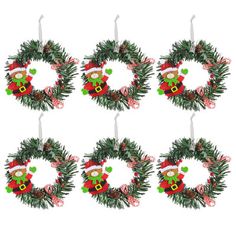 six christmas wreaths hanging from the top of each other with decorations on them and one candle