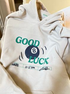 Good Luck 8 Ball Hoodie Pullover hoodie material is 50/50 cotton and polyester. Each item is uniquely printed and designed by me. Black/Green ink on Beige Clothing Unisex Sizing, S, M, L, XL, 2XL Available (Message me for XXL+ Sizing) Wash instructions: Turn inside out, wash with cold water and delicate setting. Air dry preferred. Follow specific care instructions to ensure the longevity of the design for all handmade items. Check out my Instagram and Depop for customer photos and reviews. Messa Company You Keep, Words On Hoodies, Good Christmas Presents For Teens, Original Hoodie Design, 8 Ball Sweatshirt, Cute Senior Hoodies, How Lucky Are We Sweatshirt, Cute Trendy Hoodies, Disco Ball Clothes