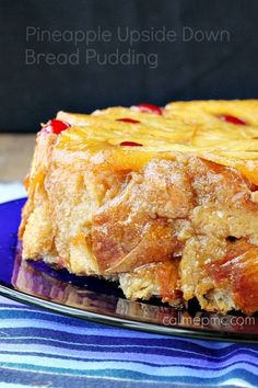 a piece of pineapple upside down bread pudding on a blue plate with a striped napkin