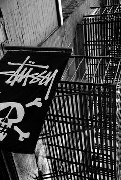 a black and white photo of a sign on the side of a building that has graffiti written on it