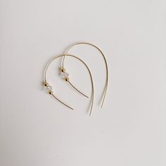 Add a touch of sparkle to your everyday outfits with our Herkimer Diamond Open Hoop Earrings. Made from one continuous 14K gold filled thread, these earrings feature a sleek, double-pointed crystal accented with tiny gold spheres. A subtle statement piece that is comfortable and easy to wear. (No need to be a gemologist to rock these!) -- Herkimer crystals measure approximately 5-7mm 14K gold filled approximate length: 1.75" Herkimer “diamonds” are affectionately named for the Herkimer County in NY where they were first discovered and mined. While not true diamonds, Herkimer crystals are like diamonds due to their clear, sparkly, and faceted characteristics. Minimalist Adjustable Crystal Earrings, Minimalist Crystal Earrings For Everyday, Minimalist Gold Hoop Threader Earrings, Gold Hoop Threader Earrings For Everyday, Gold Crystal Drop Earrings For Everyday Wear, Minimalist Single Gold Crystal Earring, Minimalist Wire Wrapped Yellow Gold Hoop Earrings, Minimalist Gold Crystal Earrings With Ear Wire, Minimalist Gold Crystal Earrings For Pierced Ears