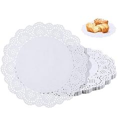 four white doily plates with crochet designs on the edges and two pastries sitting next to each other