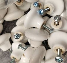 many white knobs and screws are piled together