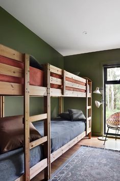 a bedroom with bunk beds and a rug on the floor in front of a window