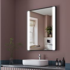 a bathroom sink sitting under a large mirror next to a wall mounted faucet