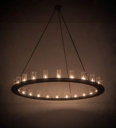 a circular chandelier with many lit candles